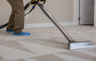 This image shows a heavy-duty vacuum machine being used to clean a carpet.