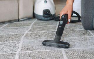 This image shows a steam cleaning machine being used to clean a carpet.